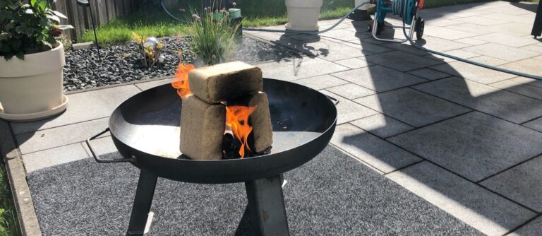 Feuerschale auf der Terrasse mit Holzbriketts und Unterlage