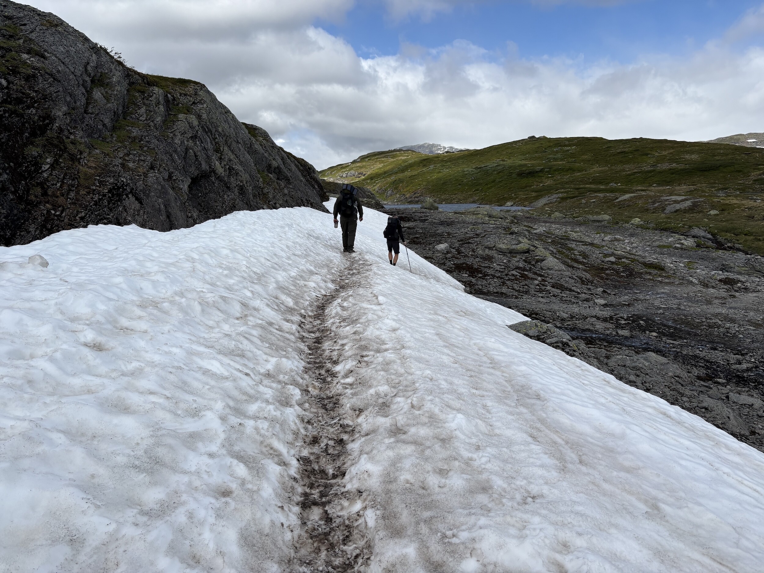 Wir gehen auf einem schmalen Pfad über ein Schneefeld in der norwegischen Hochebene