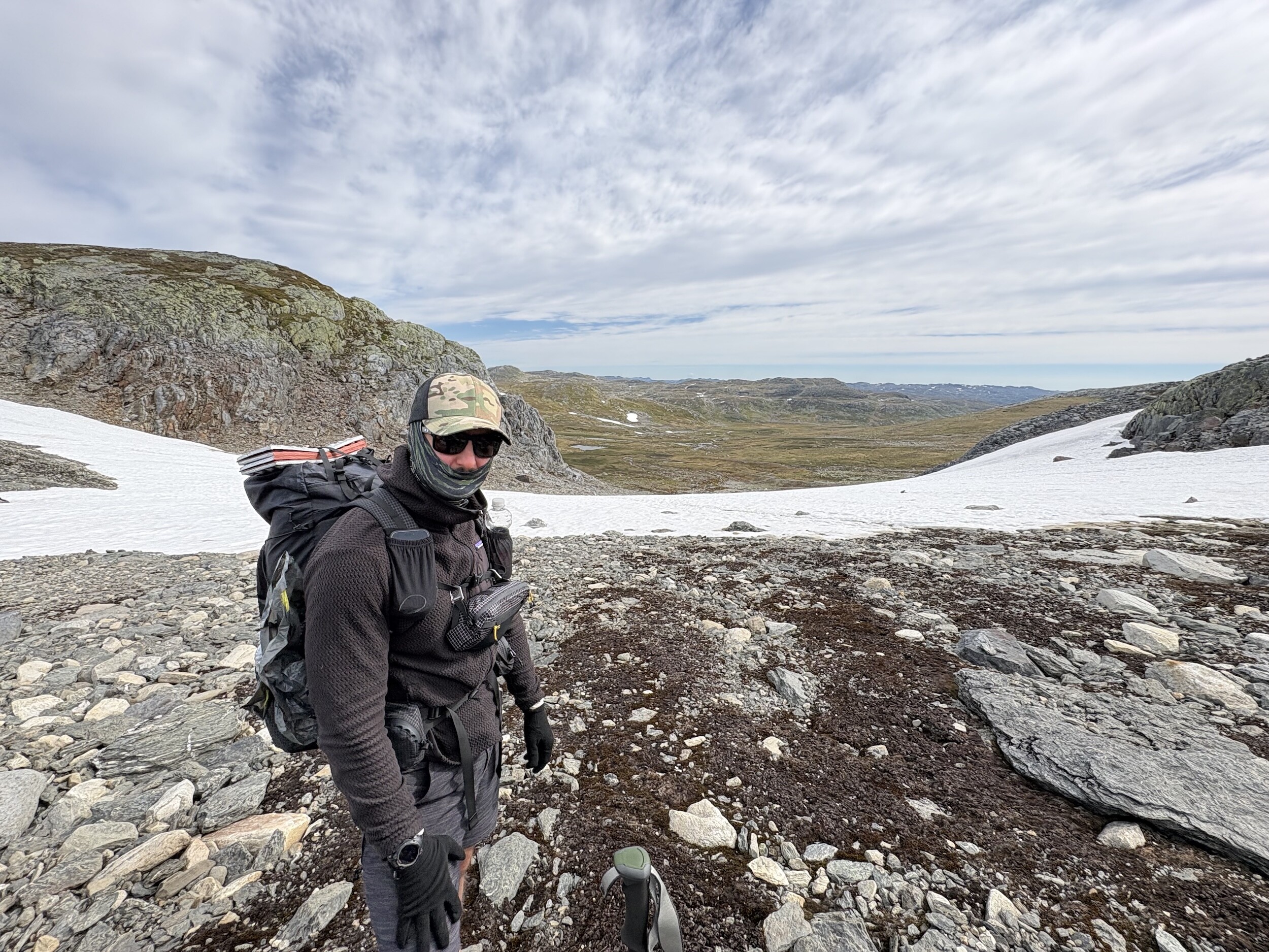 Sebastian mit schwerem Rucksack auf einer schneebedeckten Hochebene in Norwegen